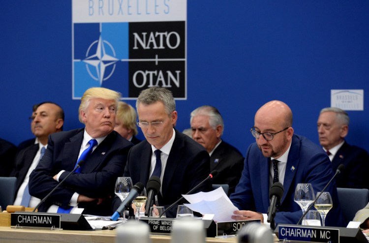 President Trump, left, sits next to NATO Secretary General Jens Stoltenberg, centre, as Belgian Prime Minister Charles Michel, right, delivers a speech, during the NATO summit of heads of state and government at the NATO headquarters in Brussels on Thursday.