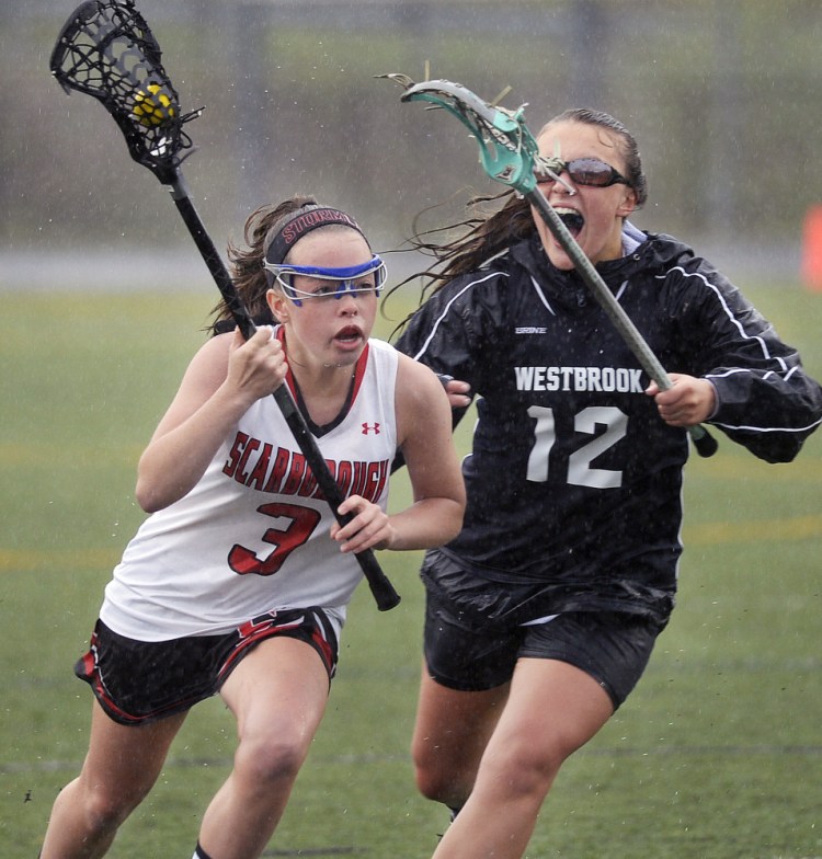 Scarborough's Sam Brodeur is chased by Westbrook's Alexis Witham during their girls' lacrosse match Thursday in Scarborough. Scarborough won, 19-10.