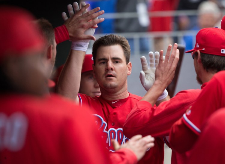 Tommy Joseph of the Phillies is welcomed by teammates Thursday after hitting a tying home run in the seventh inning against the Rockies. He also singled home the winner in the 11th.