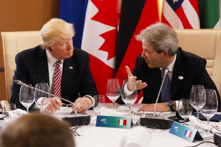 President Trump listens to Italian Prime Minister Paolo Gentiloni as they sit around a table during the G7 Summit in Taormina, Sicily.