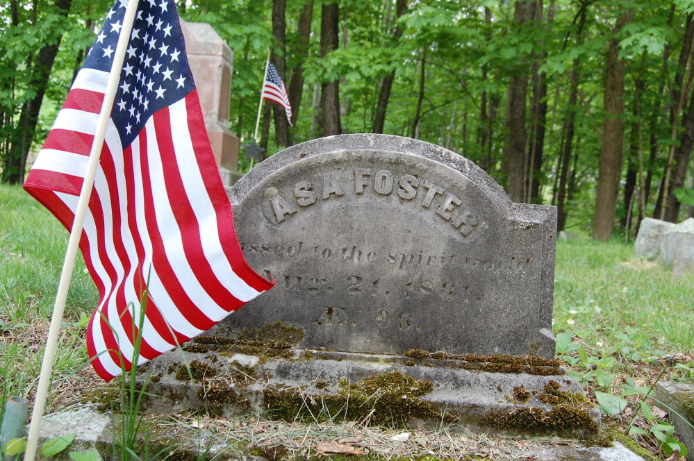In this Wednesday, May 24, 2017 photo, an American flag stands at the grave of Asa Foster, at a Canterbury, N.H., cemetery. Foster, who enlisted in the Continental Army on July 4, 1780, at age 15, and was under Gen. Benedict Arnold's command.  Canterbury recently finished a yearlong project recording the veterans buried in its 34 cemeteries, from the pre-Revolutionary War era to Vietnam. (John Goegel via AP)