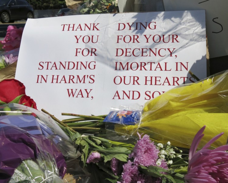 A sign of thanks rests against a traffic light pole at a memorial outside the transit center in Portland, Ore. on Saturday, May 27, 2017. People stopped with flowers, candles, signs and painted rocks for two bystanders who were stabbed to death Friday, while trying to stop a man who was yelling anti-Muslim slurs and acting aggressively toward two young women, including one wearing a Muslim head covering, on a light-trail train in Portland. Suspect Jeremy Joseph Christian, 35, was booked on suspicion of murder and attempted murder in the attack and will make a first court appearance Tuesday.