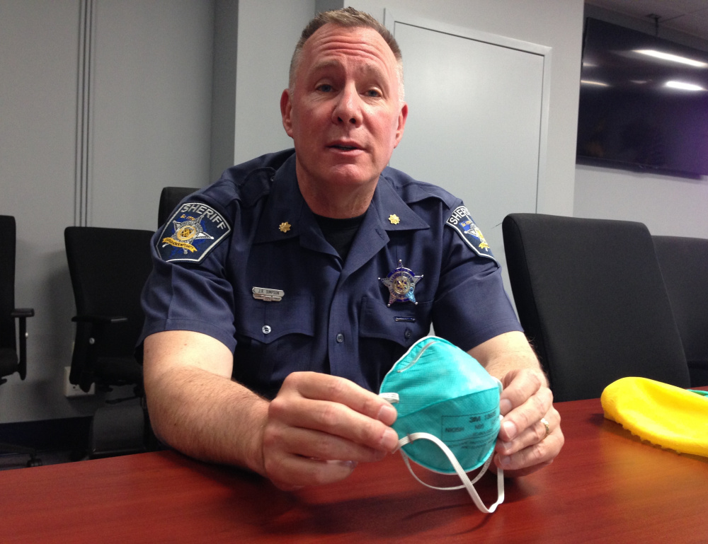Harford County (Md.) Maj. John R. Simpson displays elements of a protective suit that the sheriff's office is now providing to deputies sent to crime scenes involving heroin and synthetic opioids, some of which are powerful enough to tranquilize elephants.