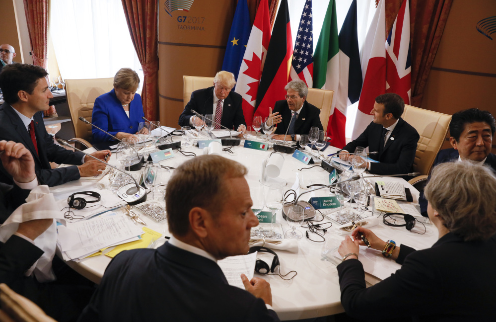 From left, Canadian Prime Minister Justin Trudeau, German Chancellor Angela Merkel, President Trump, Italian Prime Minister Paolo Gentiloni, French President Emmanuel Macron, Japanese Prime Minister Shinzo Abe, British Prime Minister Theresa May, European Council President Donald Tusk and European Commission President Jean-Claude Juncker (unseen) sit around a table during the G7 Summit in Taormina, Sicily, Italy, Friday.