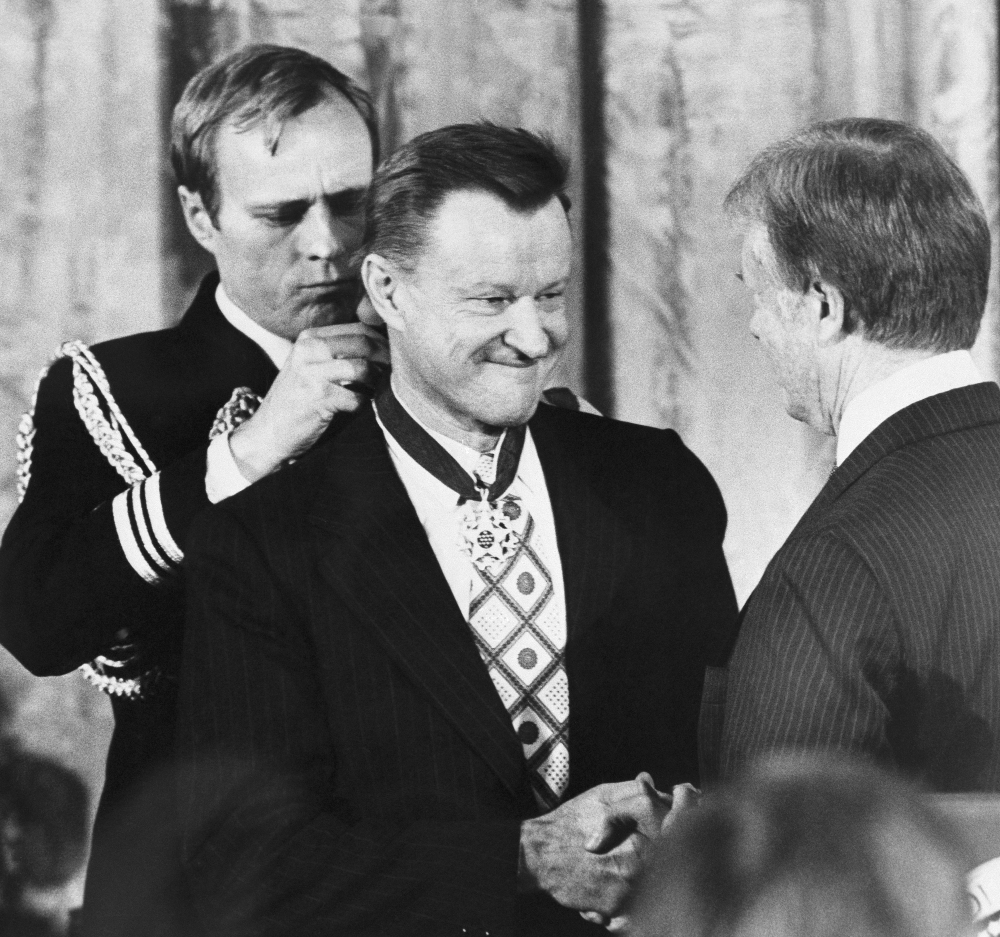 Zbigniew Brzezinski shakes hands with President Jimmy Carter as Carter presents him with the Medal of Freedom. Brzezinski, Carter's national security adviser and who helped write the Camp David accords, died Friday at age 89.