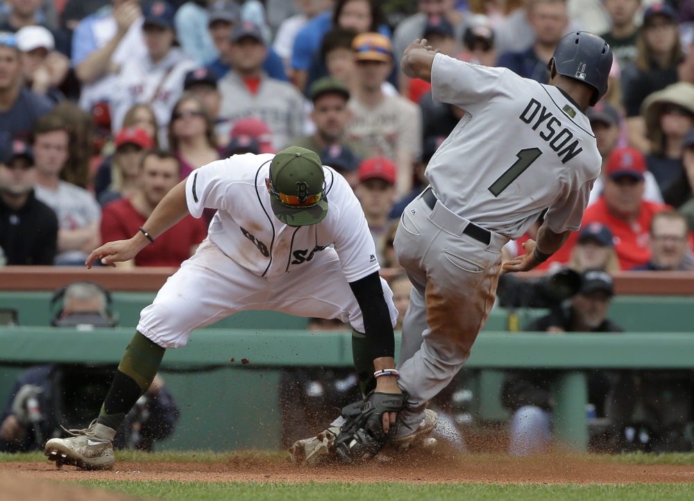 Seattle's Jarrod Dyson slides while attempting to steal third base as Boston's Deven Marrero makes the tag in the eighth inning Sunday at Fenway Park in Boston.