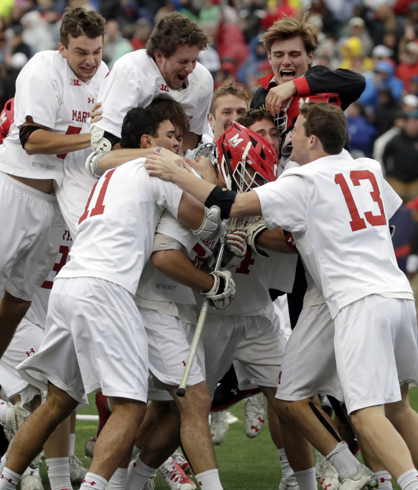 Maryland players jump on goalie Dan Morris as they celebrate their 9-6 win over Ohio State in the NCAA men's lacrosse championship game Monday in Foxborough, Mass.