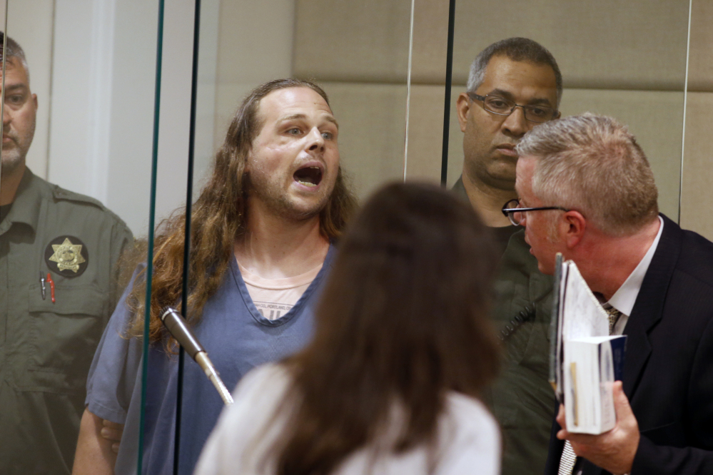 Jeremy Joseph Christian, accused of fatally stabbing two men who came to the aid of two young women he was verbally abusing, shouts as he makes his initial court appearance in Multnomah County Circuit Court in Portland, Ore., Tuesday.
At left, a sidewalk  memorial at the stabbing site.