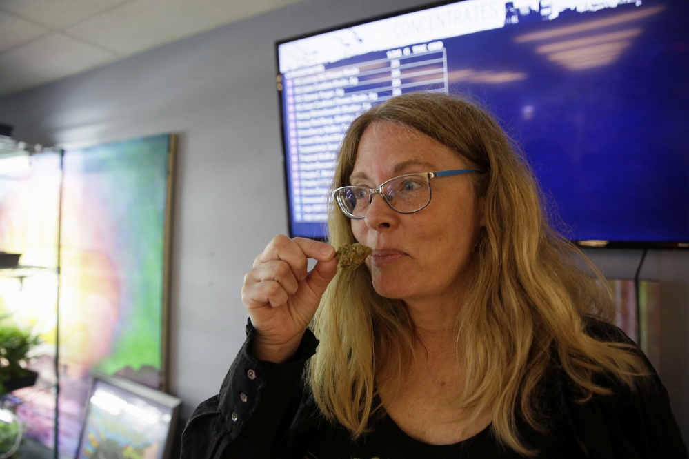 Debby Goldsberry, executive director, smells a hybrid bud at the Magnolia Wellness marijuana dispensary in Oakland, Calif.
