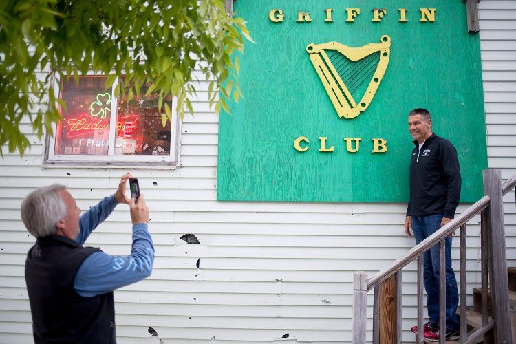 Rick Wilson takes a photo of Charlie Gordon in from of the Griffin Club sign before going in Wednesday evening. Gordon played on one of Eddie Griffin's basketball teams when he was young. He and Wilson, who had never been to the bar, drove down from Brunswick for one last drink.