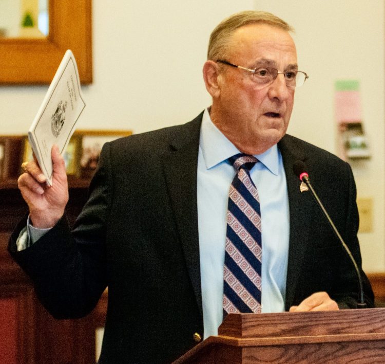 Gov. Paul LePage holds up a copy of the state Constitution as he testifies before the Legislature's Judiciary Committee on Tuesday in the State House in Augusta. LePage testified against a bill that would strip the governor of the power to approve staff pay raises within the Attorney General's Office.