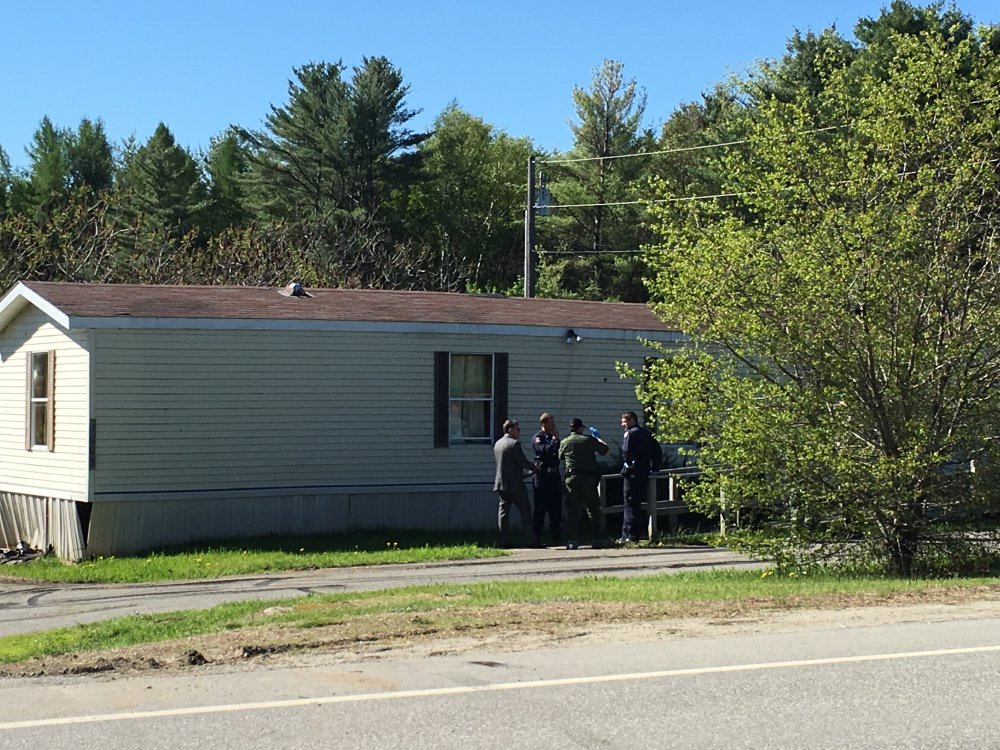 Authorities gather Saturday morning outside the Belgrade mobile home where one man was killed and one person was injured in an officer-involved shooting the previous night.