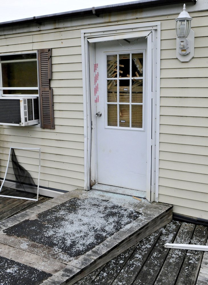 Glass from a shattered window in a door that is sealed with police evidence tape is seen at the front entrance to a mobile home at 1003 Oakland Road in Belgrade on Monday. Homeowner Roger Bubar died in a police officer-involved shooting on May 20 and his son Scott Bubar was wounded.