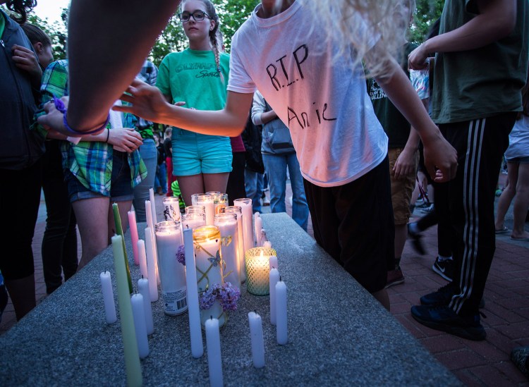 Students combine candles they lit during Wednesday night's vigil for Anie Graham.