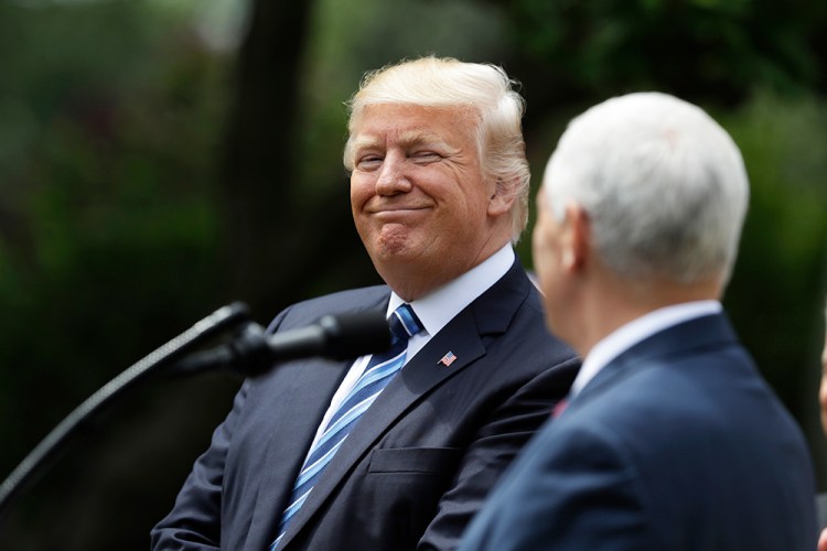 President Trump smiles toward Vice President Mike Pence in the Rose Garden Thursday, where he was to sign an executive order aimed at easing an IRS rule limiting political activity for churches. 