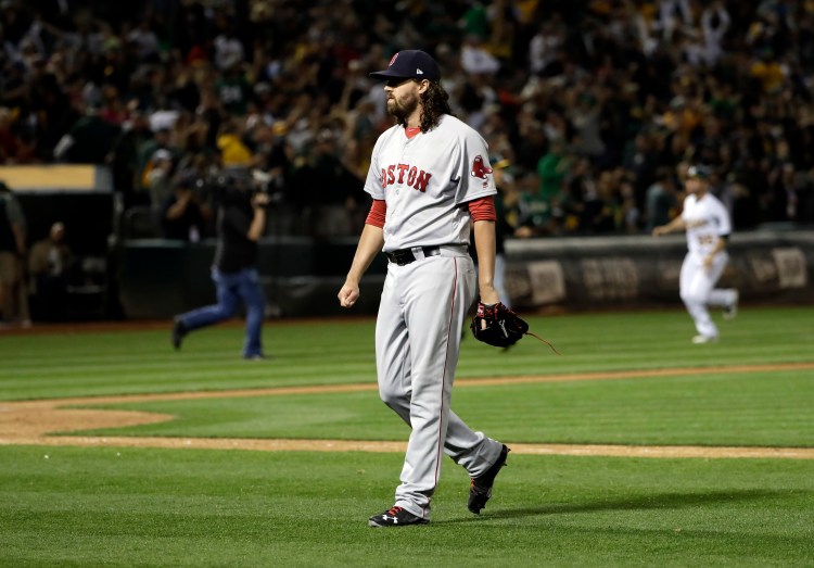 Red Sox relief pitcher Heath Hembree walks off the field after giving up a solo walk-off home run to the Oakland Athletics' Mark Canha during the 10th inning on Friday.