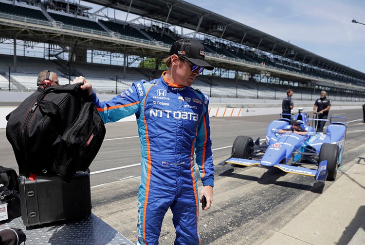 Scott Dixon, of New Zealand, grabs his helmet before the start of a practice session for the Indianapolis 500 IndyCar auto race at Indianapolis Motor Speedway, Monday. 