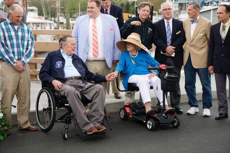 Former President George H.W. Bush and former first lady Barbara Bush hold hands while attending the rededication of the Mathew J. Lanigan Bridge over the Kennebunk River.
