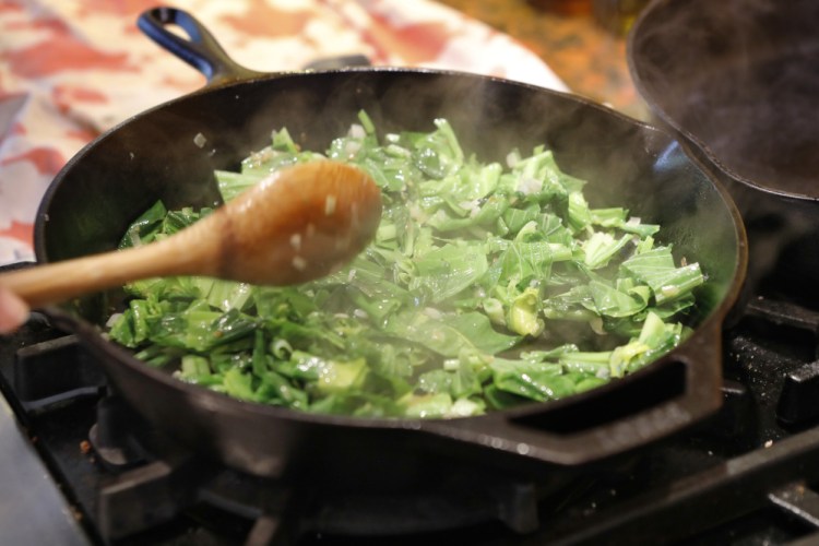 Hosta leaves and onions are sautéed in a skillet to make the filling for savory pastries.