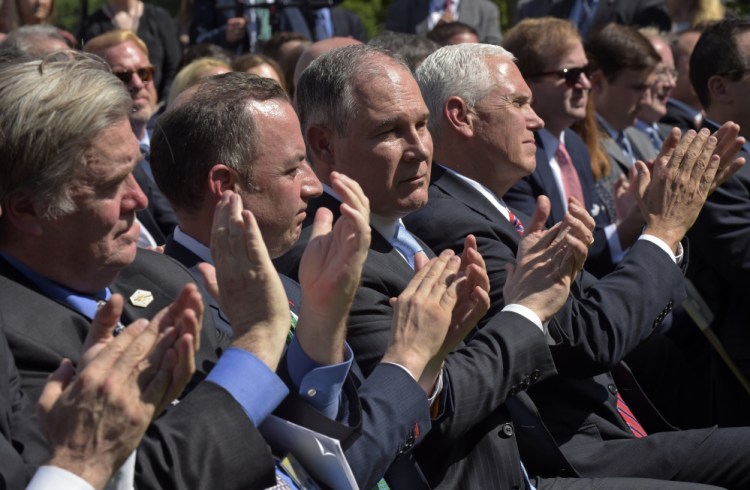 Administration officials, from left, White House chief strategist Steve Bannon, Chief of Staff Reince Priebus, Environmental Protection Agency Administrator Scott Pruitt, and Vice President Mike Pence, applaud as President Trump announces that the U.S. will withdraw from the Paris climate change accord as he speaks in the Rose Garden of the White House on Thursday.