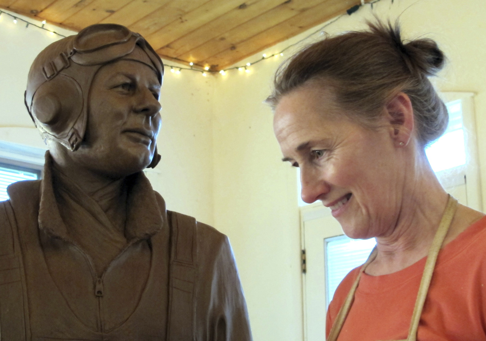 Sculptor Susan Geissler works on a clay likeness of World War II hero C. Wade McClusky Jr. in her Youngstown, N.Y., studio. The model will form the basis for a bronze monument in McClusky's honor.