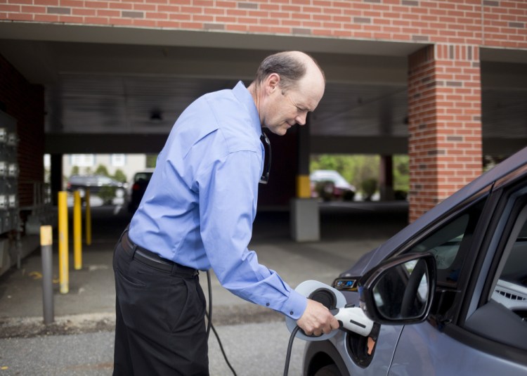 Barry Woods, 56, whose job with ReVision Energy of Portland is to promote electric cars, shows how to charge his Chevy Bolt, which he calls a game changer.