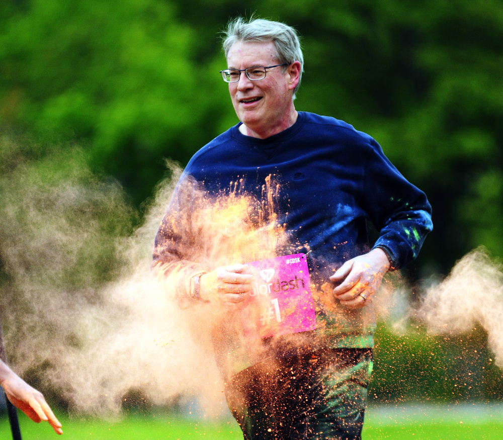 A runner's hit with orange powder Saturday at the Kennebec Valley YMCA during a 5K Color Dash race in Augusta.