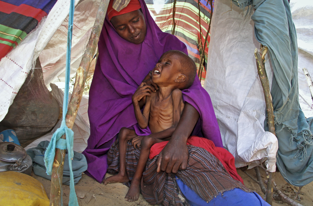A newly displaced Somali mother comforts her malnourished child in their makeshift shelter at a camp in the Garasbaley area on the outskirts of Mogadishu, Somalia.