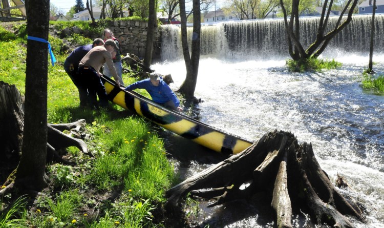 Men remove a canoe below the dam on Outlet Stream in Vassalboro on May 16, the day after Mollie Egold of Vassalboro and her son William, 5, went over the dam and he was thrown from the canoe. William was pulled from the water but died in the hospital of severe hypothermia.