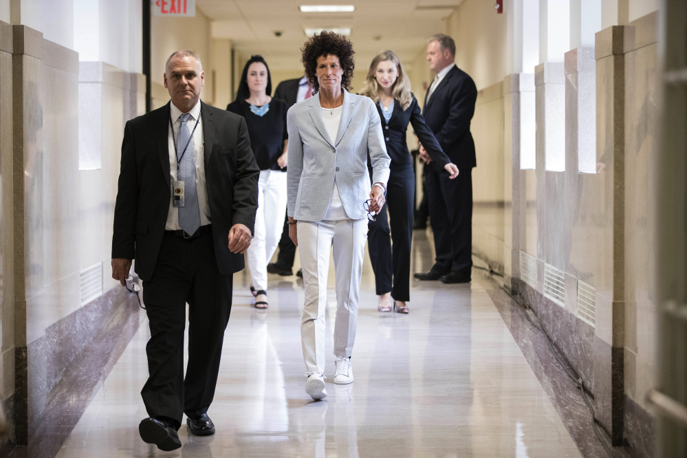Andrea Constand, center, walks to the courtroom during Bill Cosby's sexual assault trial at the Montgomery County Courthouse in Norristown, Pa., on Tuesday. Cosby is accused of drugging and sexually assaulting Constand at his home outside Philadelphia in 2004.