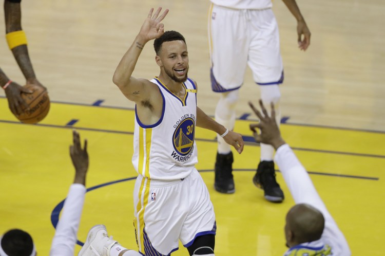 Golden State guard Stephen Curry gestures after scoring against Cleveland during Game 2 of the NBA Finals on Sunday in Oakland. The Warriors made a finals record 18 3-pointers in a blowout victory.