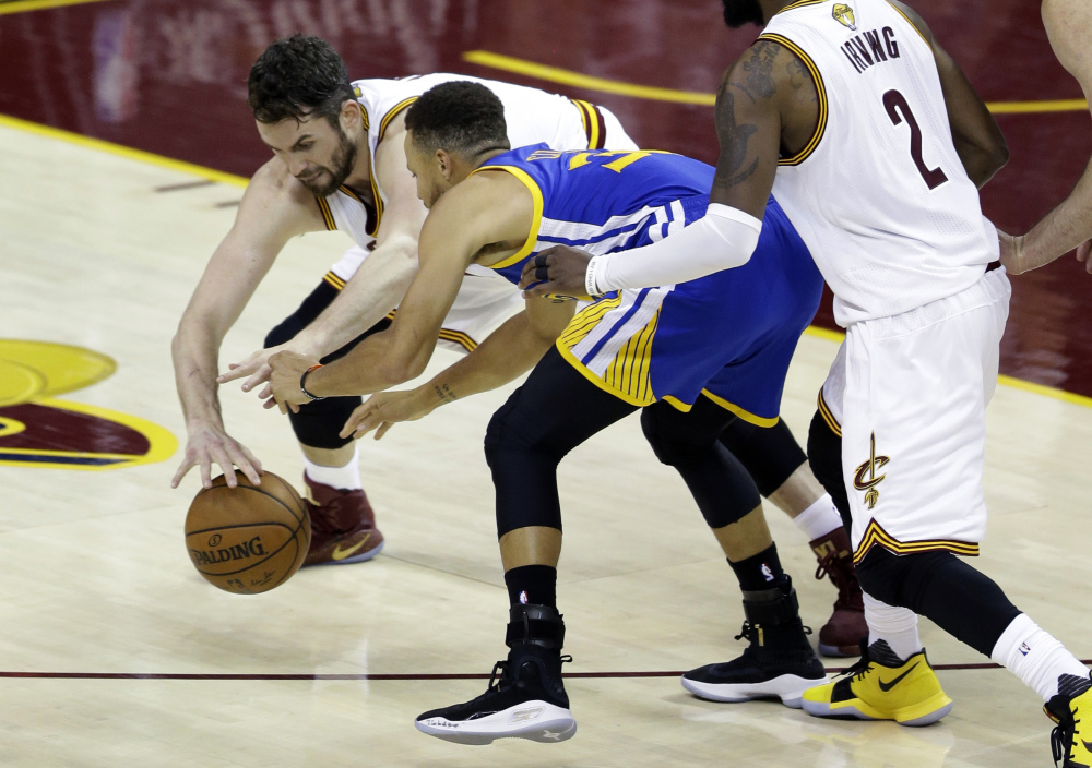Cavaliers forward Kevin Love, left, defends Golden State's Stephen Curry during the second half of Game 3 of NBA Finals Wednesday night in Cleveland.