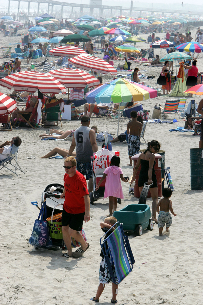 ** ADVANCE FOR MONDAY, JULY 23 ** People walk on a crowded beach in Ocean City, N.J., Tuesday, July 17, 2007. That time-honored New Jersey tradition of sneaking onto the beach without paying could get much harder soon in this south Jersey community, which is considering eliminating beach badges and issuing electronic bracelets to paying customers. That would enable authorities to wirelessly "sweep" the beach and instantly know who has a beach badge, and who doesn't. (AP photo/Mel Evans)