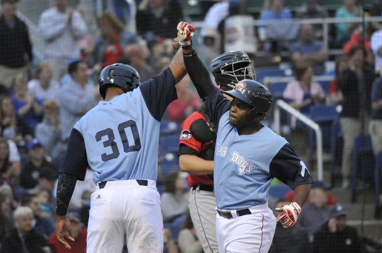 Josh Tobias, right, is greeted at home plate by teammate Jeremy Barfield after Tobias' three-run home run against the Erie SeaWolves on Friday at Hadlock Field. Portland won 7-5 on Nick Longhi's two-run home run with two outs in the bottom of the ninth.