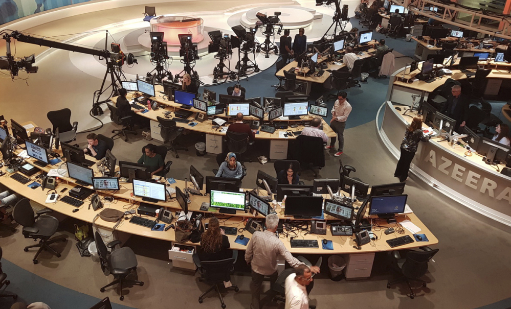 Al-Jazeera staff work at their TV station in Doha, Qatar, on Thursday. Critics allege that the news network that is widely seen on Arab channels worldwide is promoting Islamist movements as a tool of Qatar's foreign policy.
