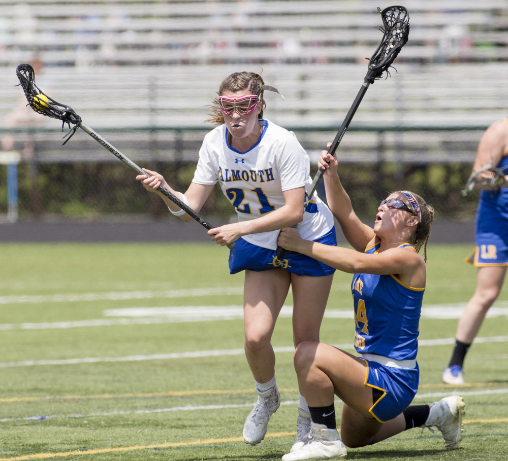 Lake Region's Olivia Deschenes, right, tries to keep her balance as she defends Falmouth's Sydney Bell during their Class B South semifinal Saturday in Falmouth. Bell collected two goals and two assists in Falmouth's 13-12 win.