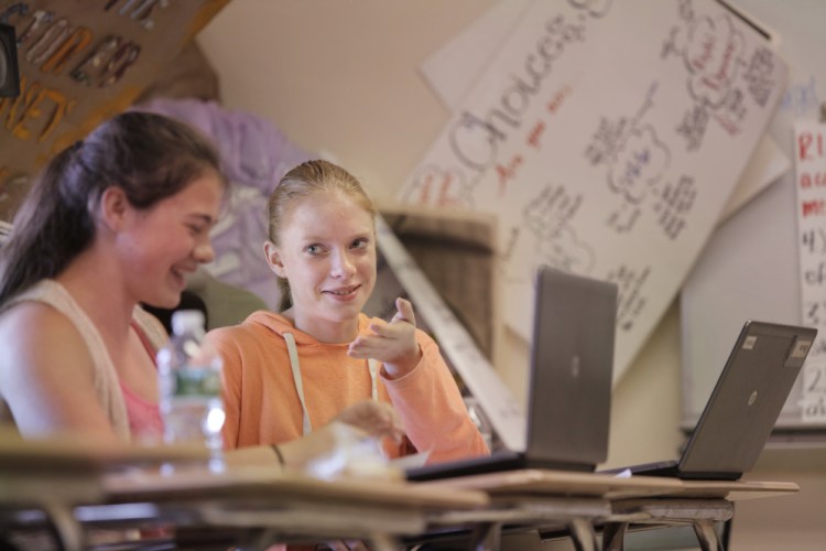 Nokomis Regional High School freshman Kylee Elderkin, right, speaks with classmate Sierra Robichaud while the two work on an assignment in their English class at the Newport school recently. "I definitely would have struggled" in algebra, Elderkin says, if she hadn't been allowed to retake tests on elements she hadn't yet mastered.