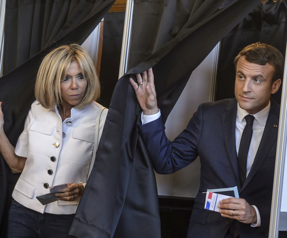 French President Emmanuel Macron and his wife, Brigitte, leave a polling booth after voting in the first round of the two-stage legislative elections in Le Touquet, France, on Sunday.
