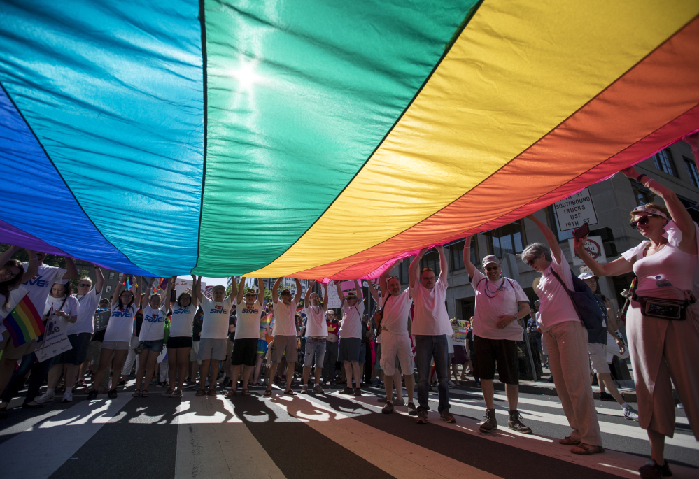 Marchers unfurl a huge rainbow flag as they prepare to march in the Equality March for Unity and Pride in Washington on Sunday. Thousands paraded past the White House.