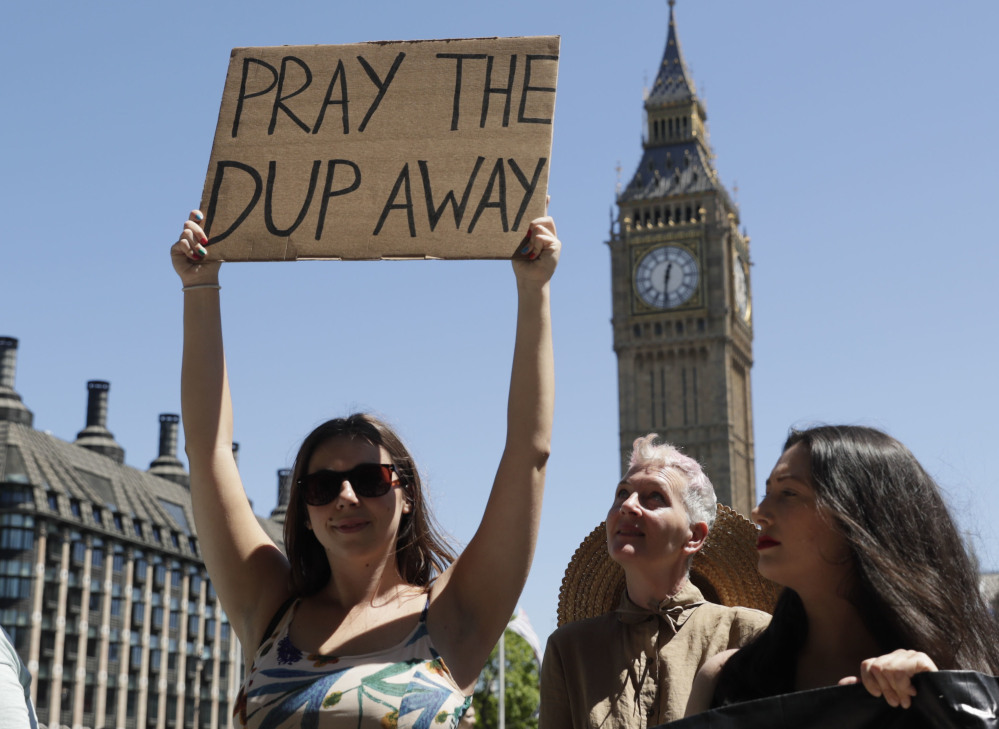 People demonstrate in Parliament Square in London against the Conservative and Northern Irish party agreement that was reached after Britain's general election Saturday.