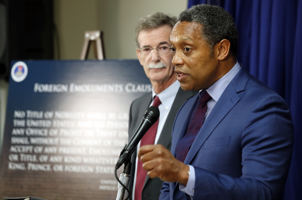 Maryland Attorney General Brian Frosh listens at left as District of Columbia Attorney General Karl Racine answers a question during a news conference in Washington Monday to announce what they call a "major lawsuit" against President Trump. The lawsuit cites Trump's leases, properties and other business "entanglements" around the world as the reason for the suit, saying those posed a conflict of interest under a clause of the Constitution.