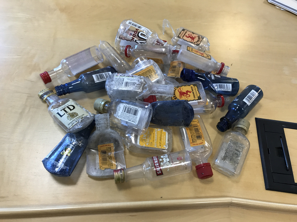 A cache of empty miniature liquor bottles known as "nips" sits on a legislative committee desk on Monday. Lawmakers are considering applying Maine's 15-cent liquor bottle deposit law to nips to encourage recycling and discourage littering. Staff photo by Kevin Miller/Staff writer
