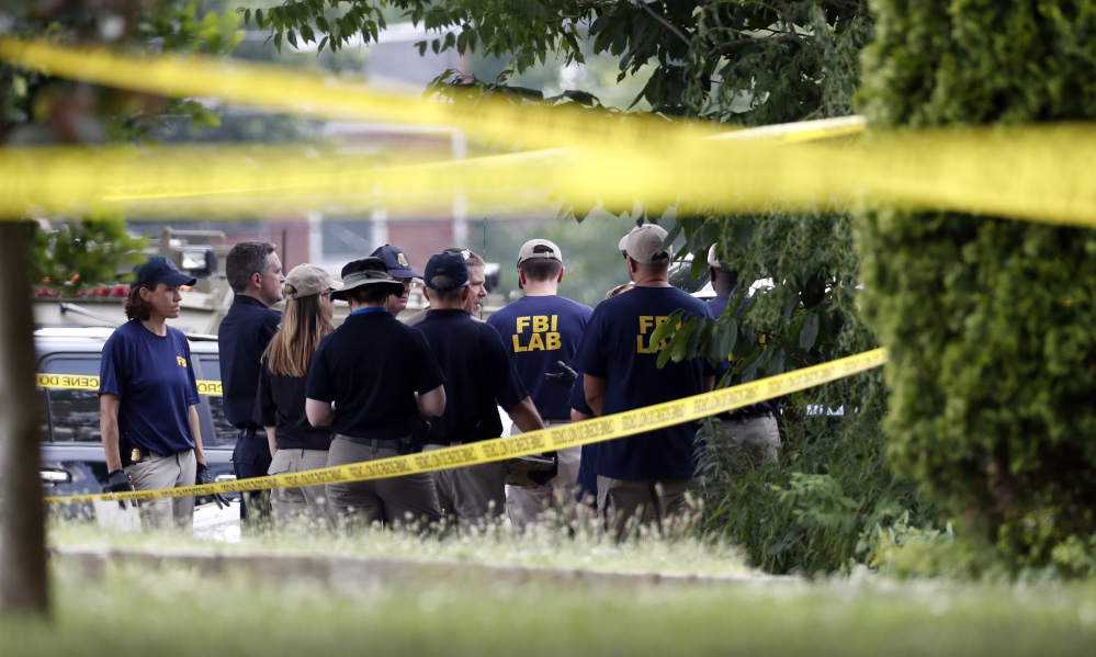 Investigators confer before looking for evidence around the baseball field in Alexandria, Va., on Wednesday, that was the scene of a shooting involving House Majority Whip Steve Scalise of Louisians and others, during congressional baseball practice.
