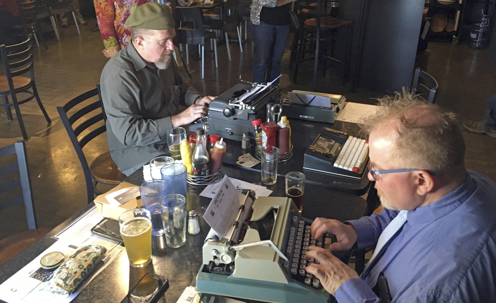 Joe Van Cleave, left, and Rich Boucher try out vintage typewriters at a "type-in" in Albuquerque, N.M., on April 23. "Type-ins" are social gatherings in public places where typewriter fans test different vintage machines.