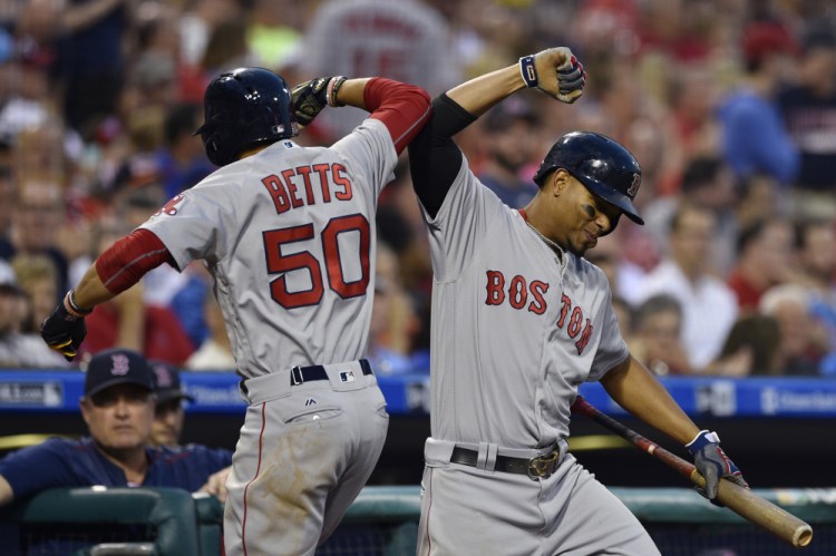 Boston's Mookie Betts celebrates with Xander Bogaerts after Betts hit a solo home run off Philadelphia's Jeremy Hellickson in the fourth inning Wednesday night in Philadelphia.