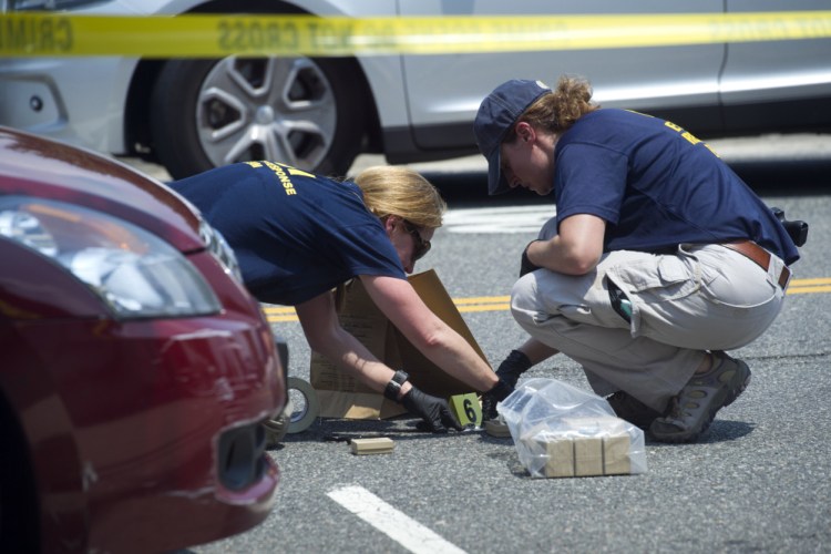 FBI Evidence Response Team members mark evidence at the scene of Wednesday's shooting in Alexandria, Va., in which House Majority Whip Steve Scalise of Louisiana and four others were shot during a congressional baseball practice.