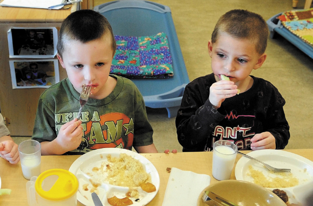 Justis Greene, 4, and Kayder Johnson, 5, eat lunch at Educare Central Maine in Waterville, in February 2013.