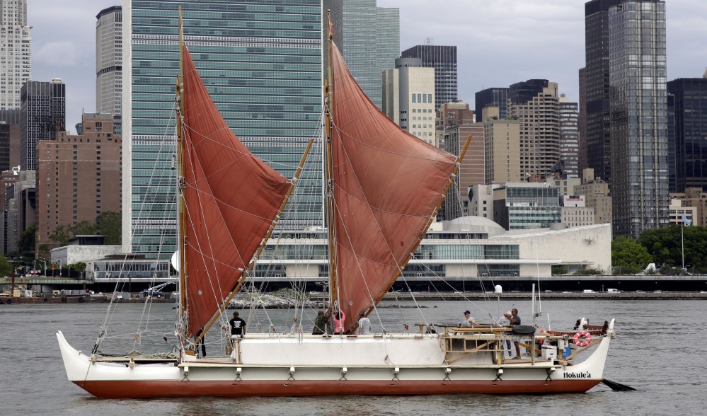 The traditional Polynesian voyaging canoe Hokulea, on an around-the-world journey guided only by nature, sails by the United Nations on New York's East River, during World Oceans Day on June 8, 2016.