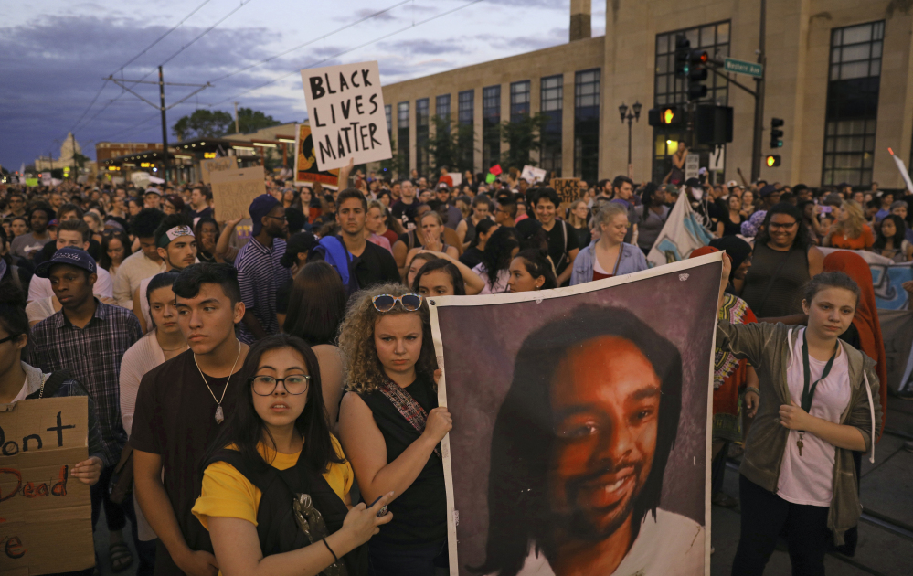 Marchers hold a portrait of Philandro Castile during a vigil Friday in St. Paul, Minn. The vigil follows police Officer Jeronimo Yanez being cleared of charges in the fatal shooting of Castile.