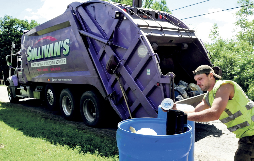 Jerry Allen, an employee of Sullivan's Waste Disposal, empties recyclable materials into a company truck recently. The Thorndike company's contract with the city of Waterville expires at the end of this month.